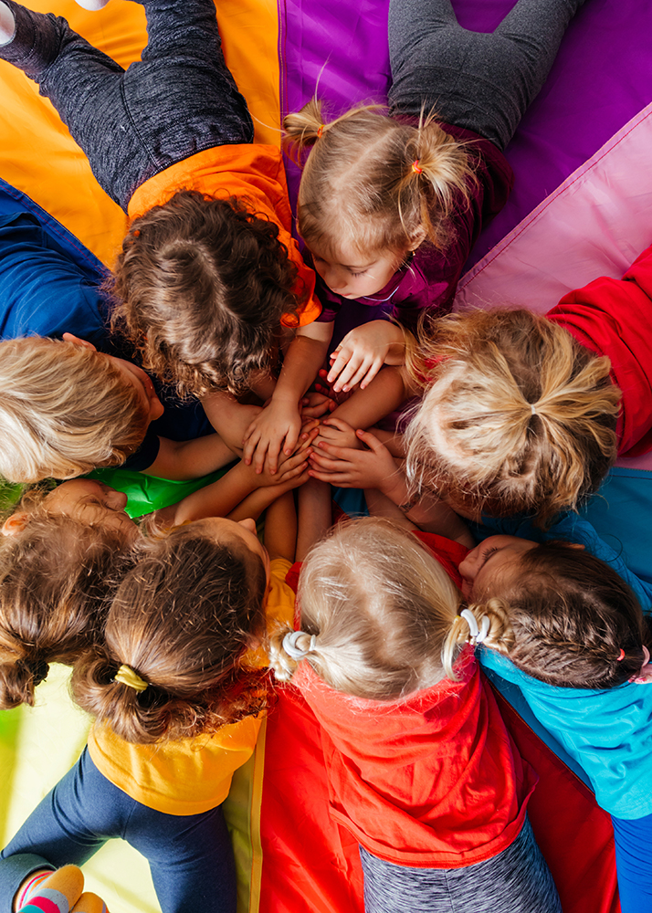 Cheerful children playing team building games on a floor