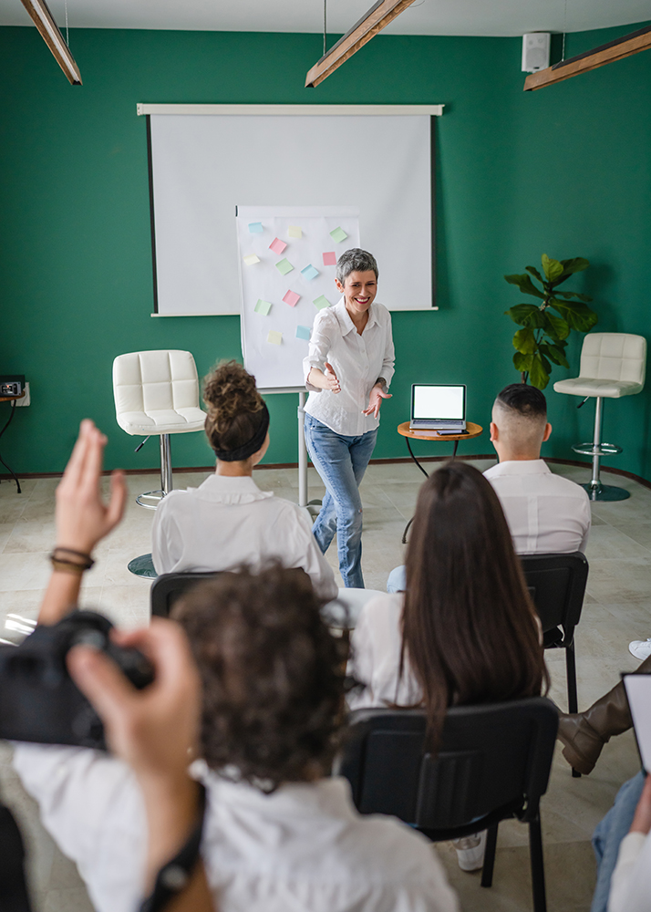 coach training speak explain question to group of employees at seminar